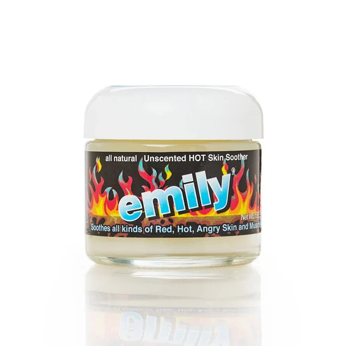 A small clear plastic jar of Emily Unscented Hot Skin Soother with a white lid and a black label featuring colorful flame graphics and the brand name 'emily' in large blue letters, shown on a white background with a reflection below.