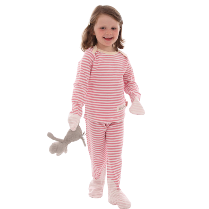 Toddler girl holding stuffed animal and wearing pink and white striped Scratchsleeves pajamas for eczema prone skin.