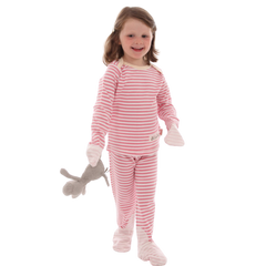 Toddler girl holding stuffed animal and wearing pink and white striped Scratchsleeves pajamas for eczema prone skin.